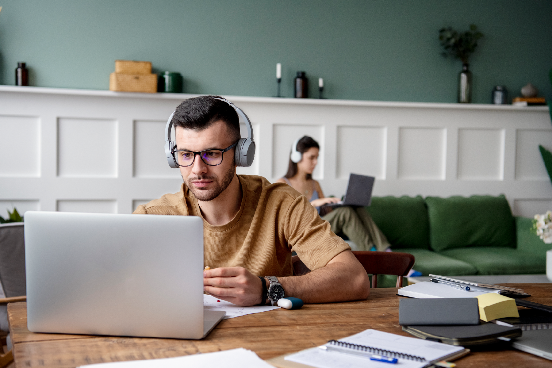 A man wearing headphones looking at a laptop