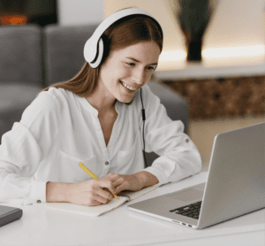 A woman sat at a laptop taking notes