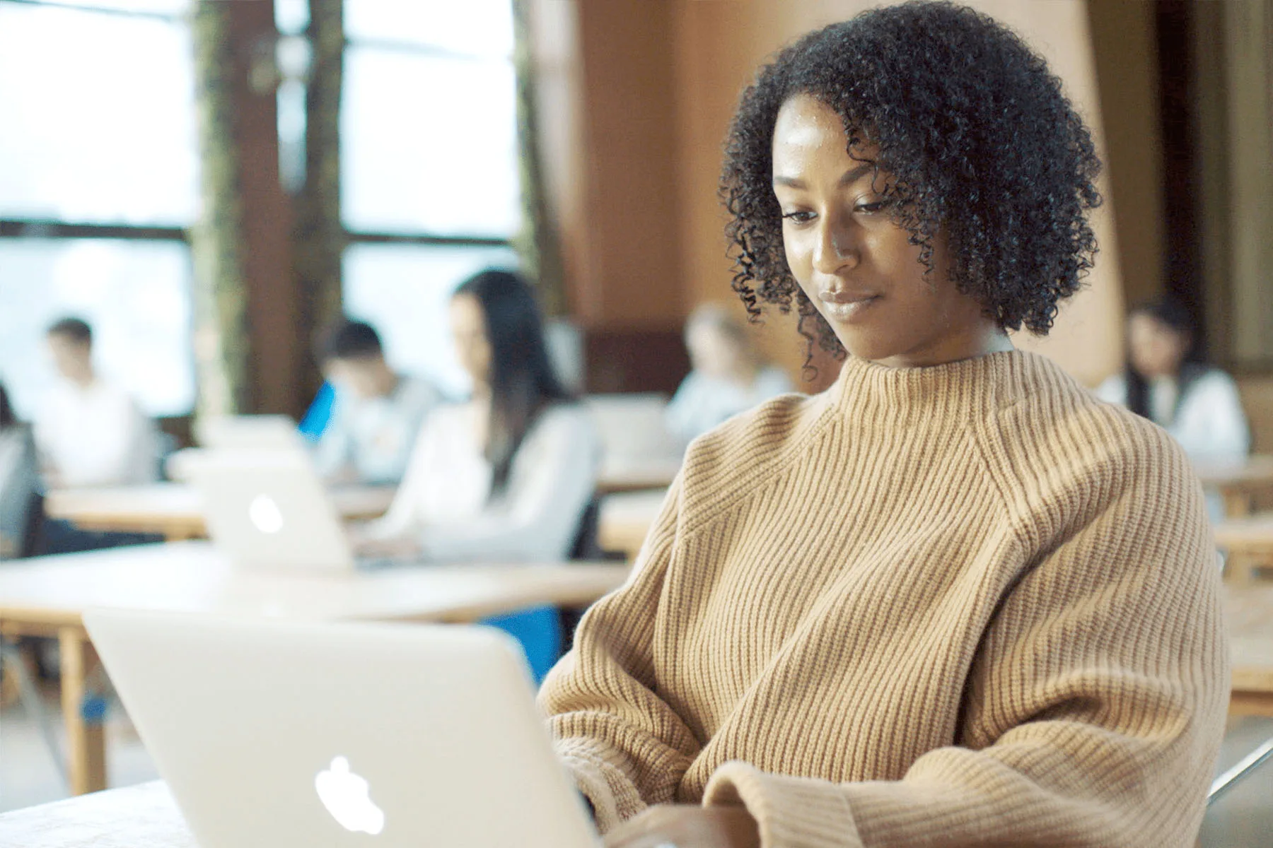 A girl working on a laptop in a classroom